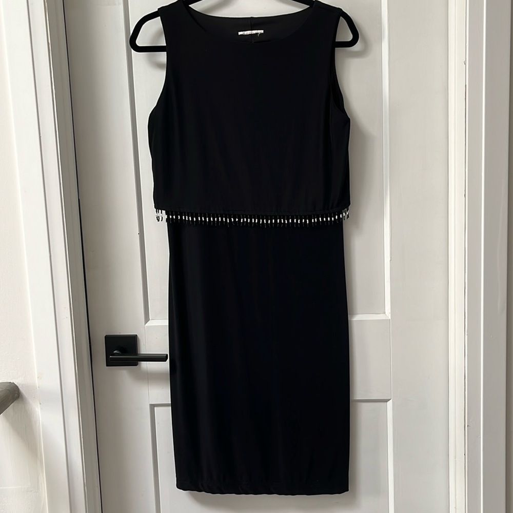 Black fitted midi dress with beaded fringes under bust line.